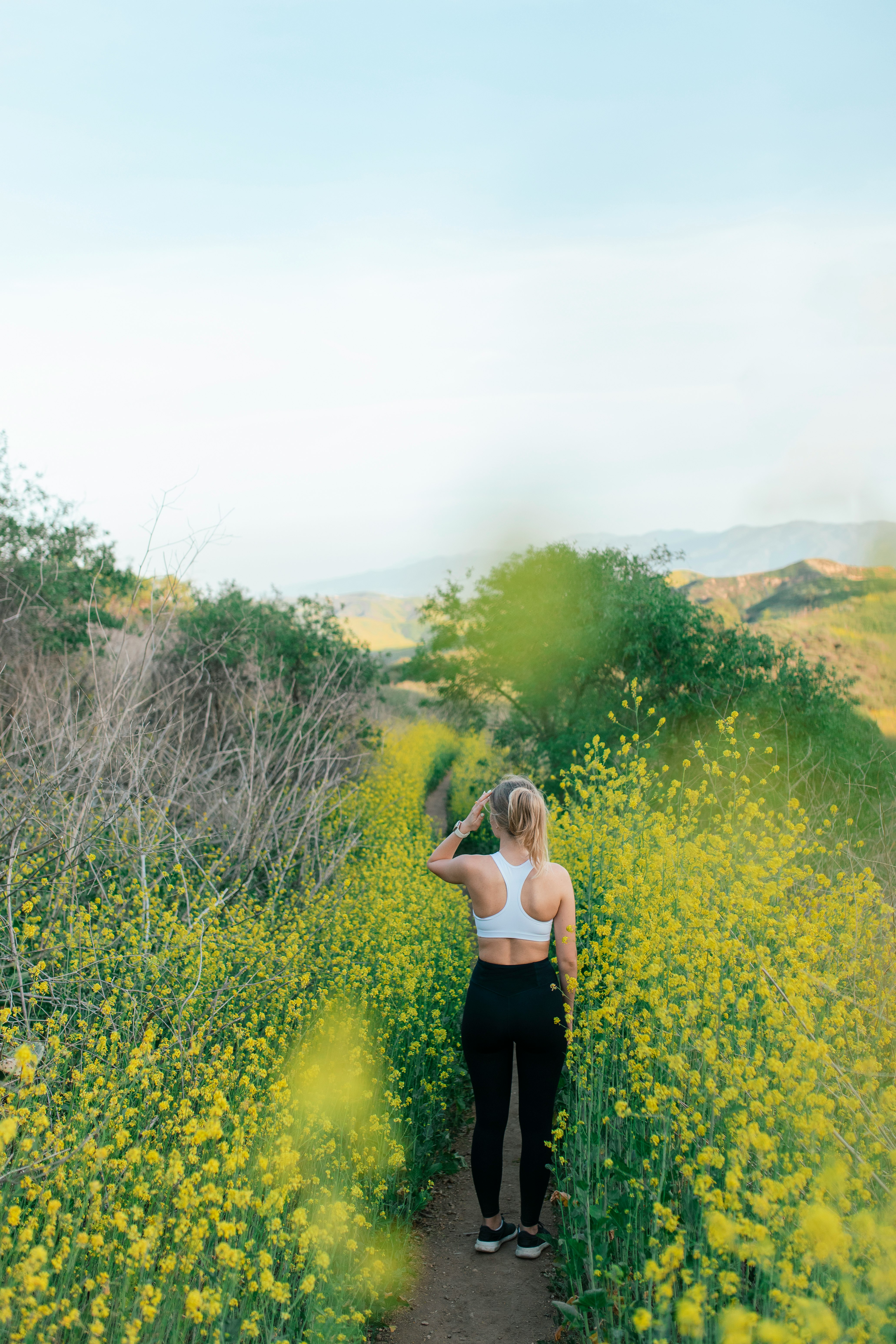 woman in black tank top standing on green grass field during daytime